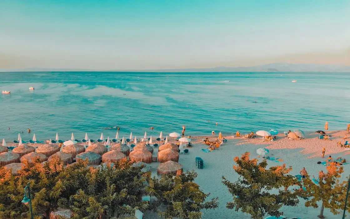 Pefkochori Beach on Kassandra with parasols and blue sea in the evening light