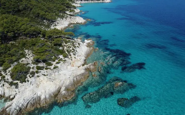 White rocks, pine trees and blue sea along the Kavourotrypes coast in Sithonia